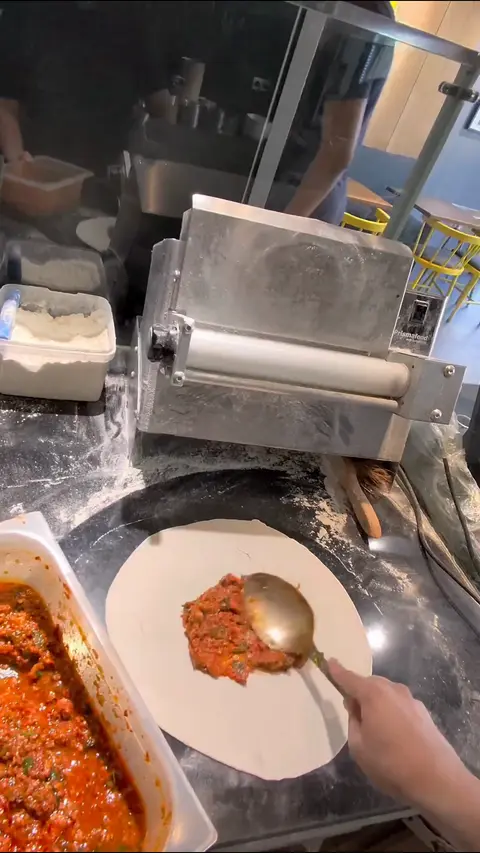 Reel-Standbild: Hackfleisch wird auf den Lahmacun-Teig gestrichen